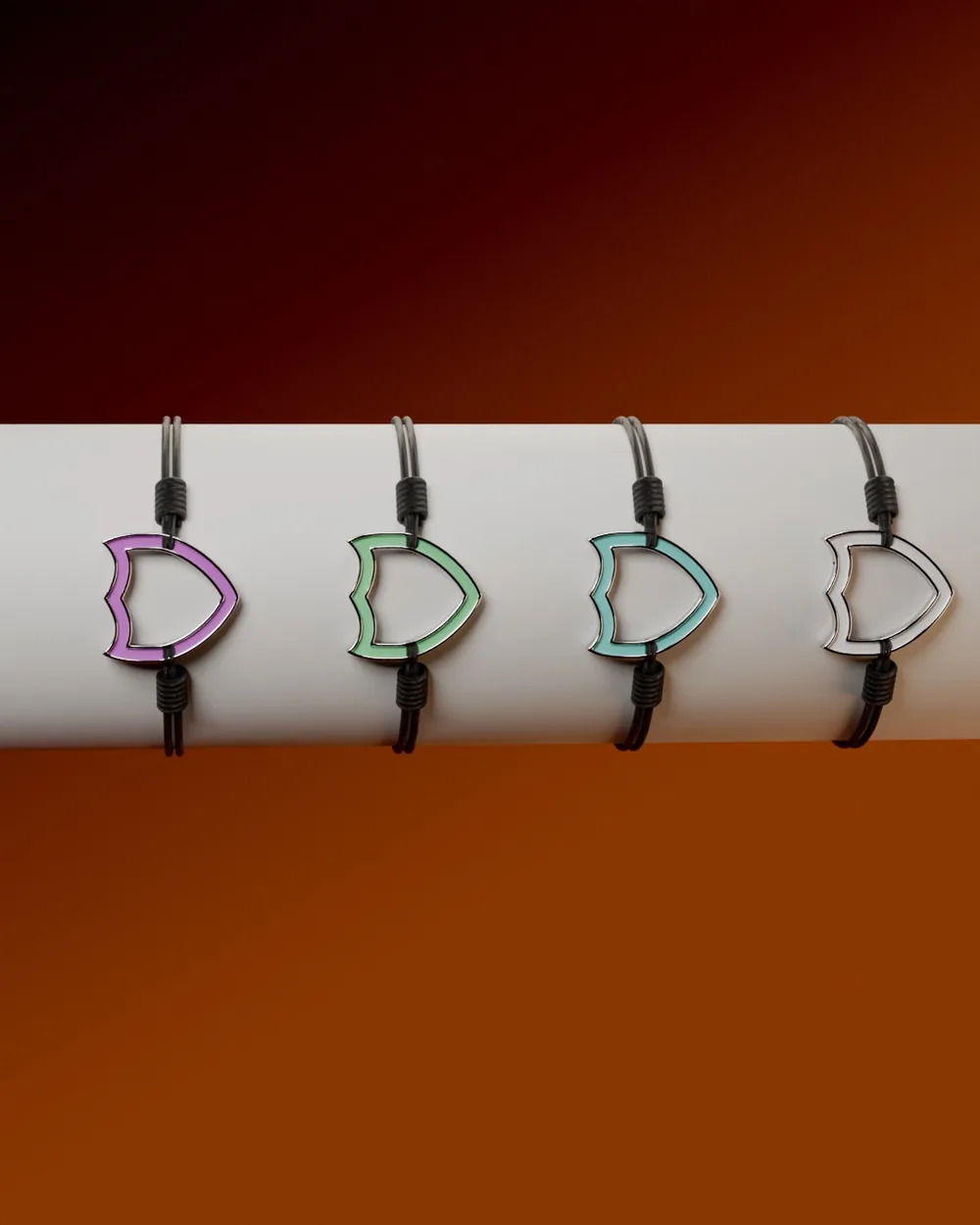 Quatre bracelets Saint & Co, rose, vert, turquoise et blanc, sur un présentoir